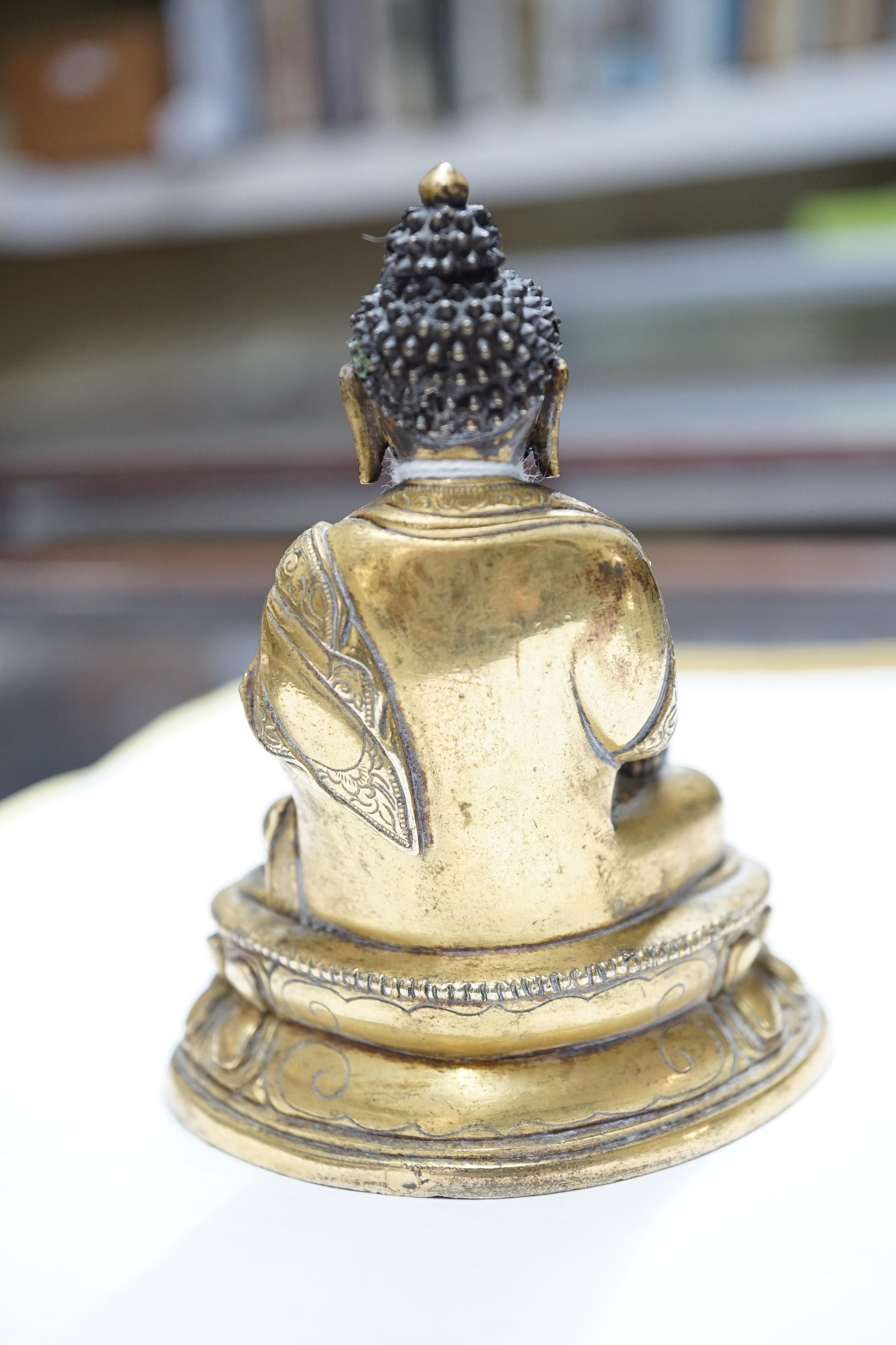A small Tibetan gilt bronze seated figure of Buddha Shakyamuni, 18th century, 9.5cm high, lacking bowl in left hand